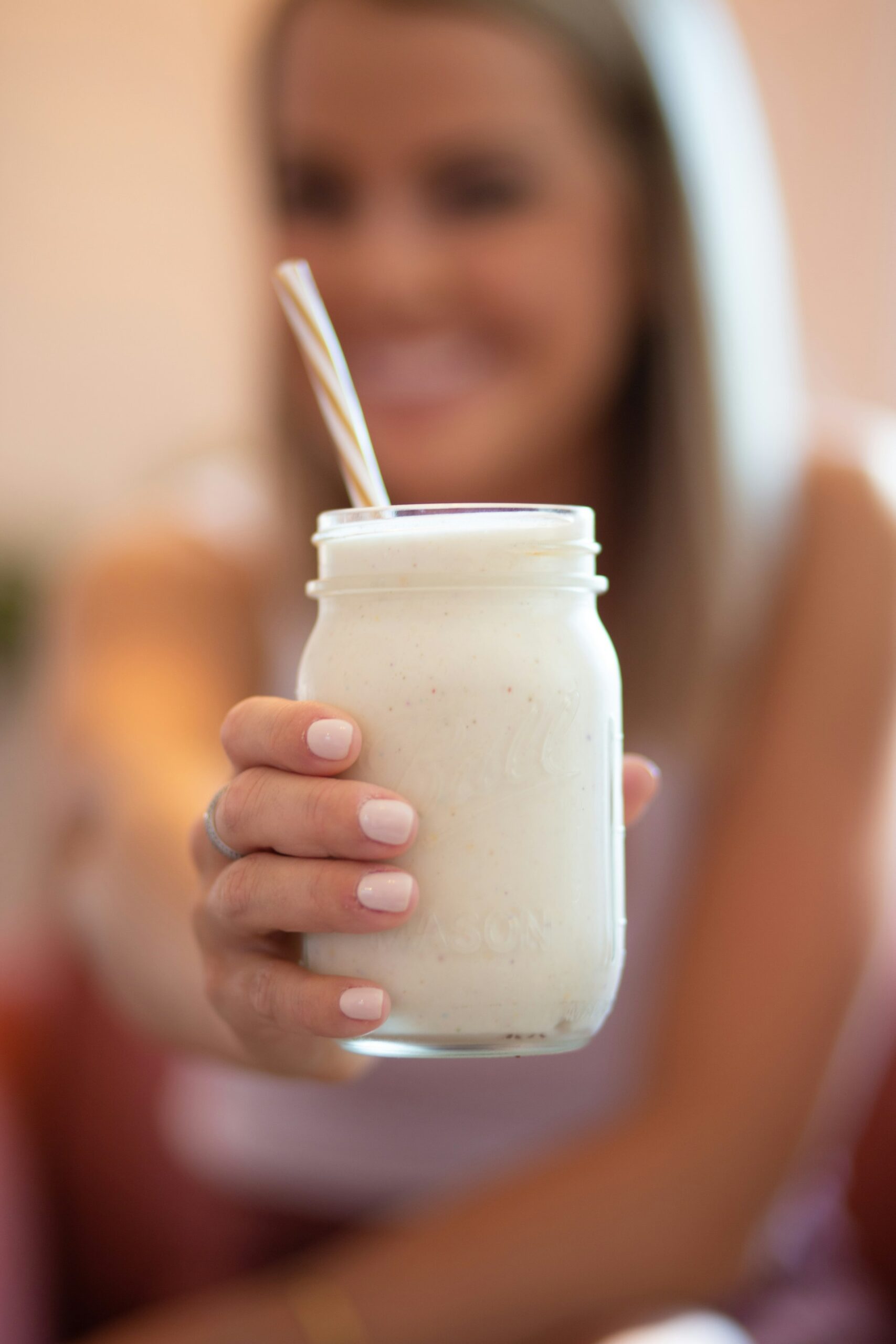 An image of a woman holding a protein shake.