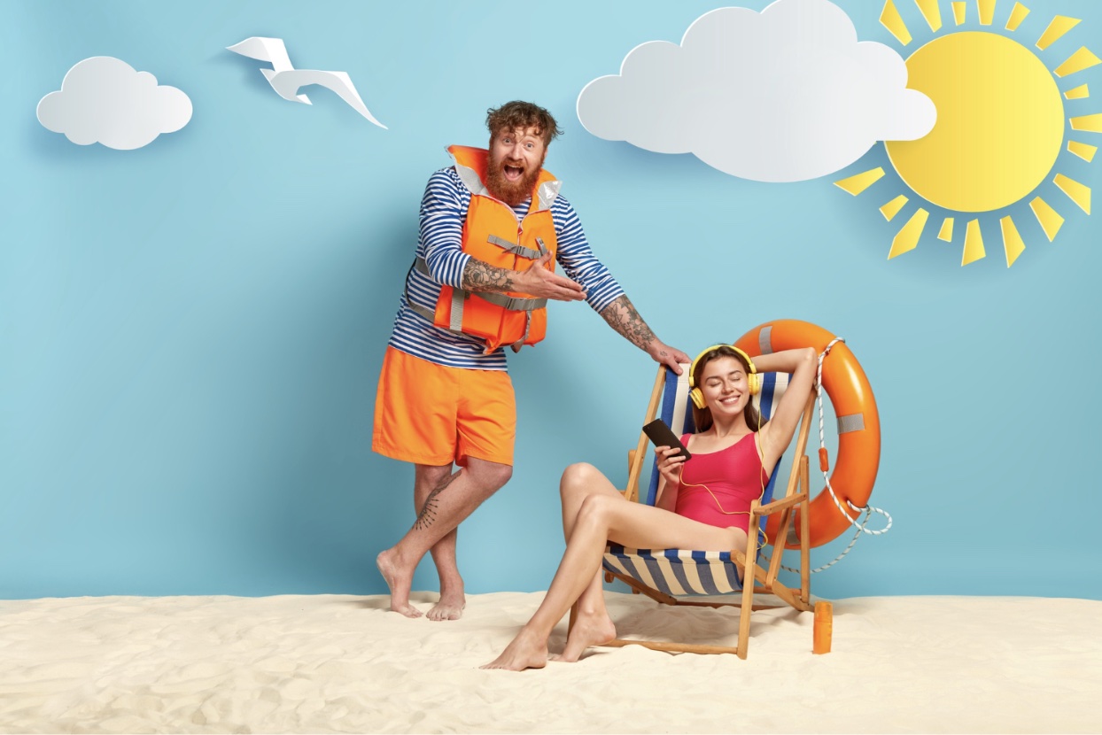 An image of two people posing in with a fake beach backdrop.