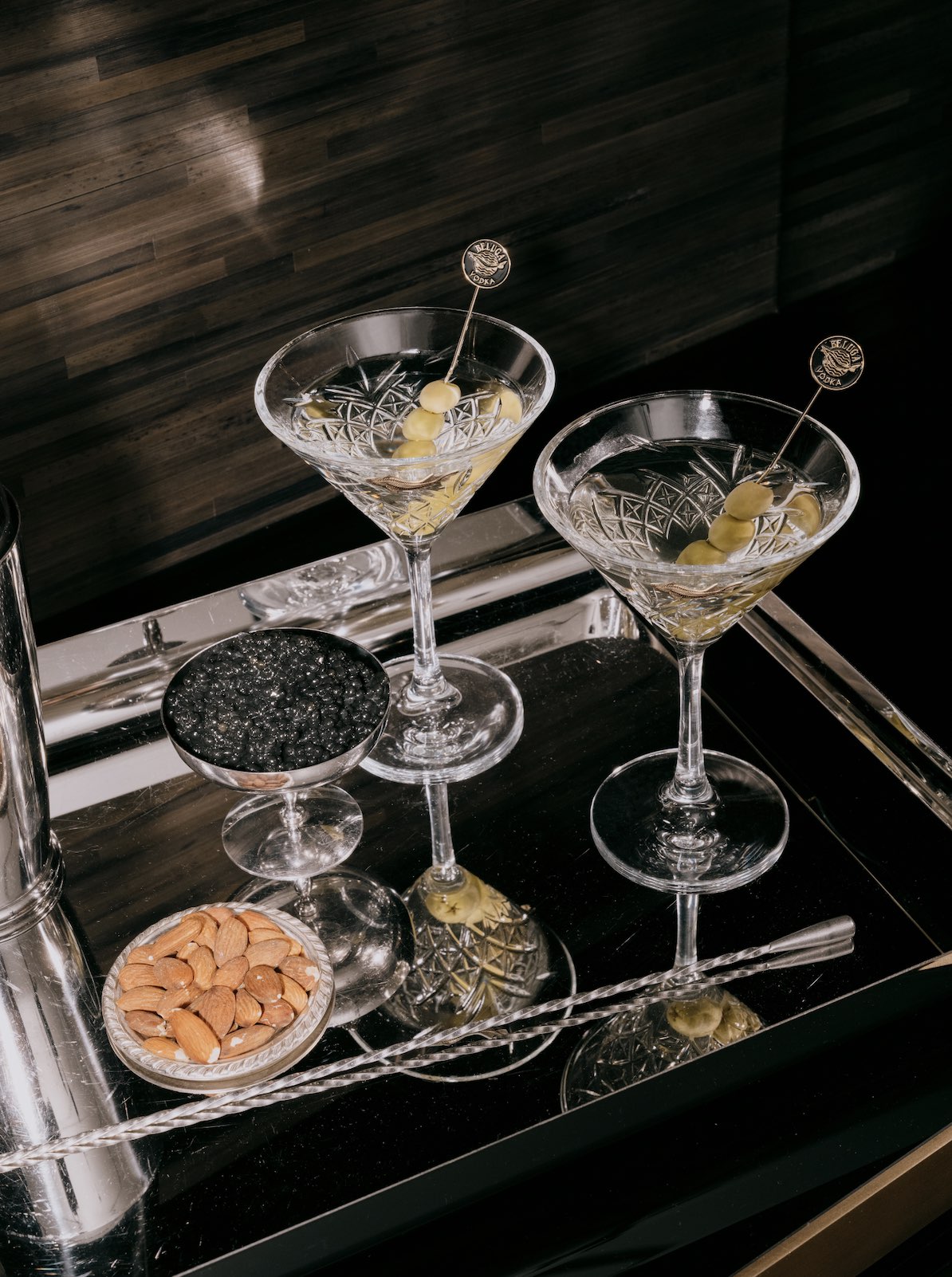 An image of a tray of caviar and two martinis.