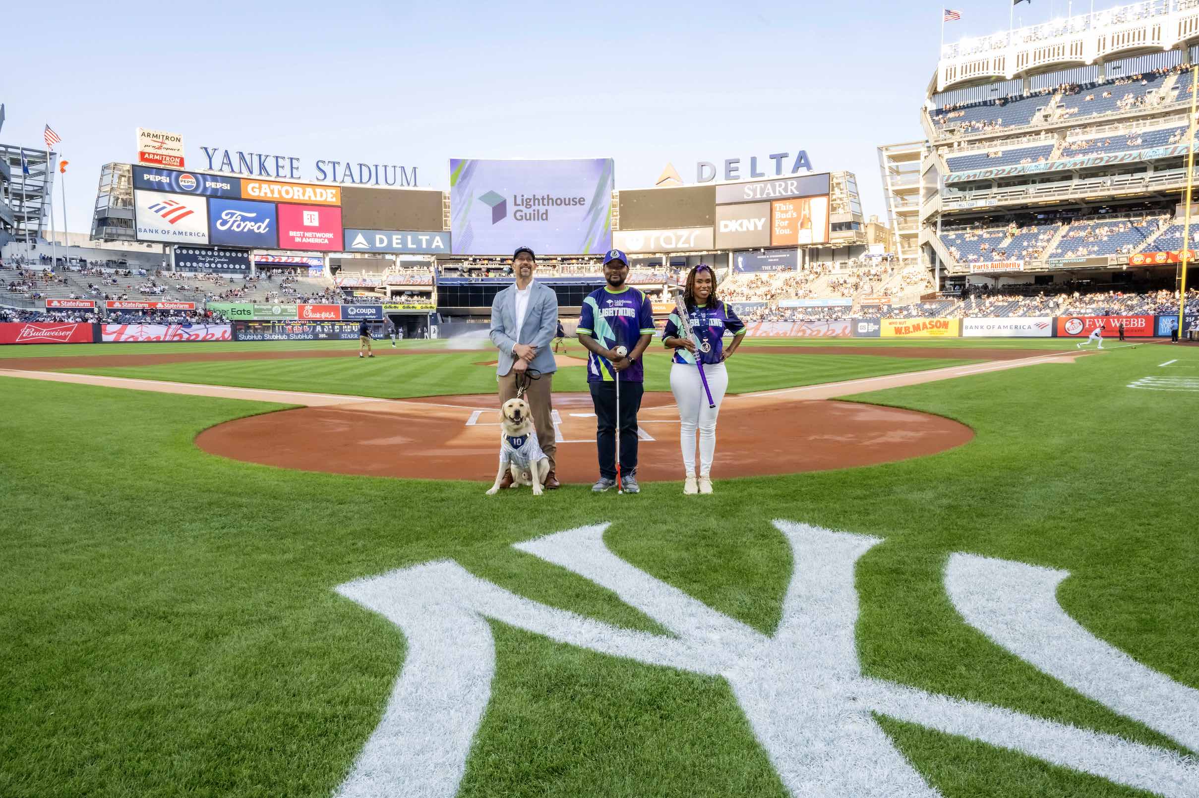 An image of Lighthouse Guild President & CEO Thomas Panek and his guide dog, Ten (named by Eli Manning), and blind baseball players Kiana Glanton and Terrell Dobbins taking part in the 35th Anniversary Of Americans with Disabilities Act (ADA) celebration