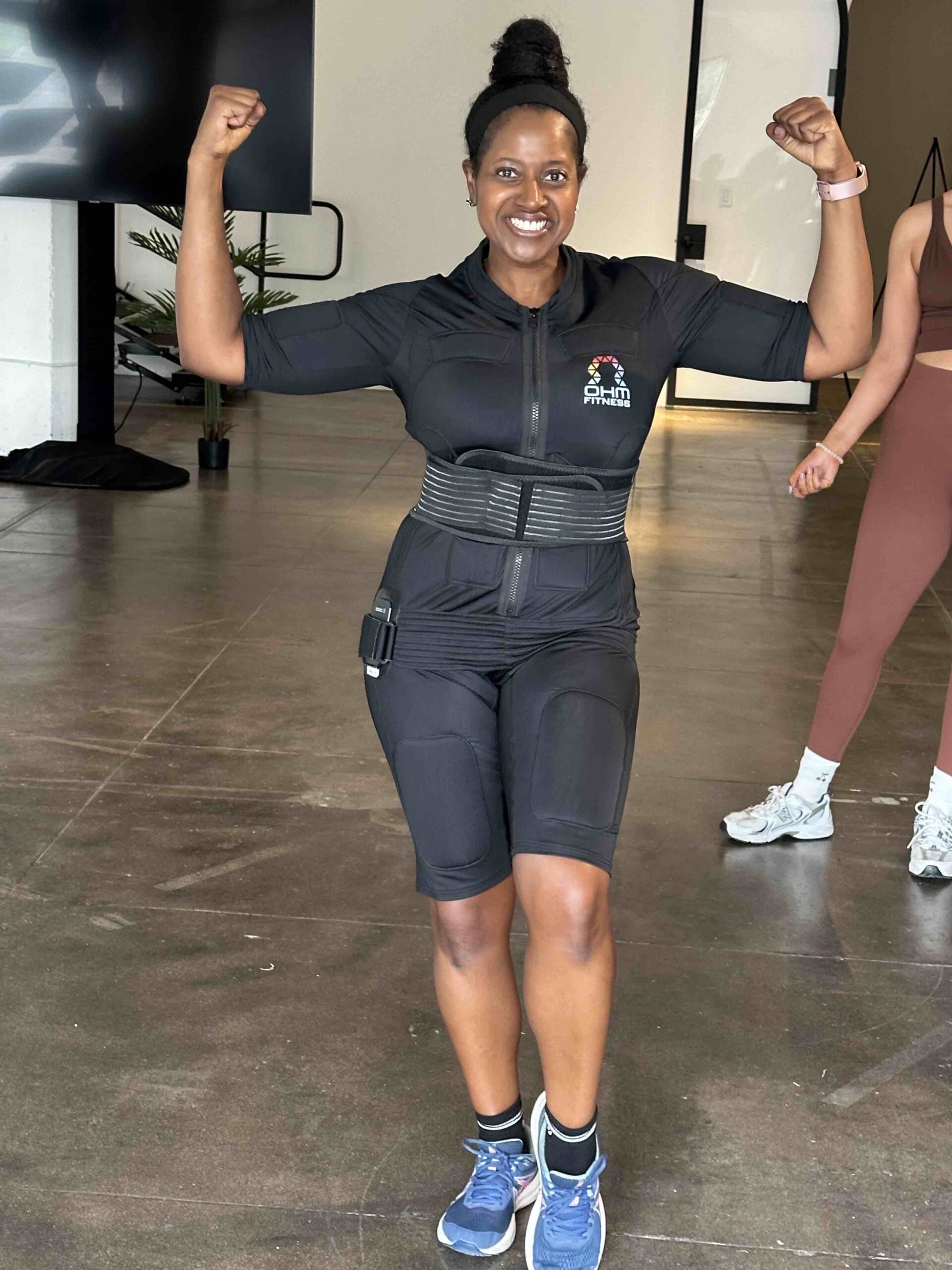 An image of lifestyle blogger Ariel wearing an OHM Fitness Electro-Pulse Fitness Suit.