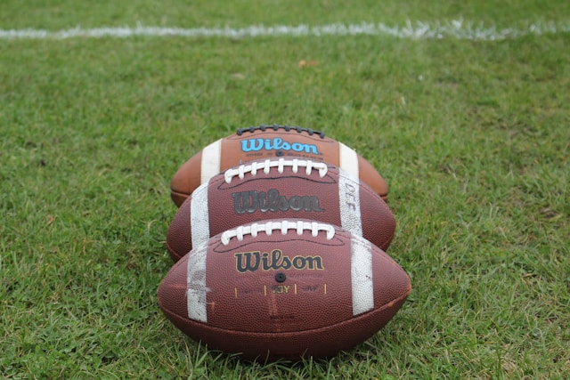 An image of thee footballs on a football field.