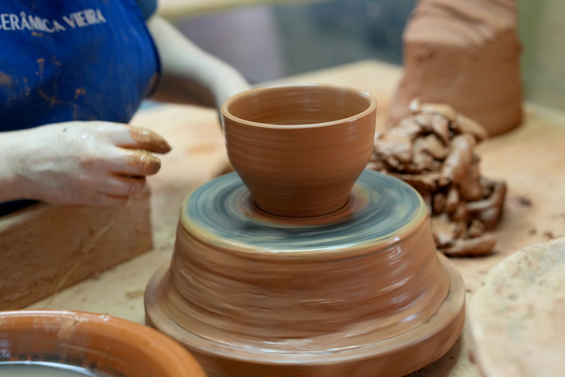 An image of someone sculpting a pot out of clay.