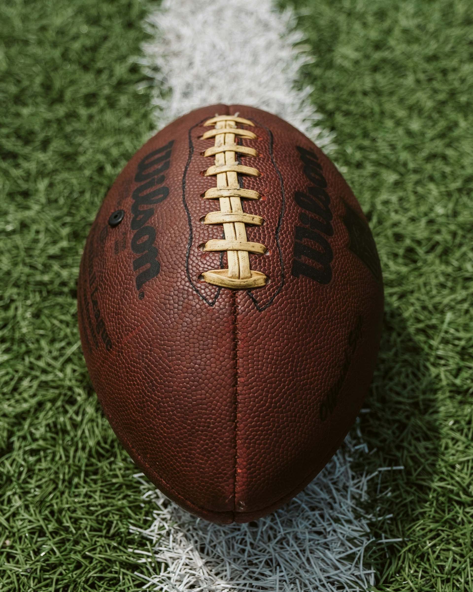 An image of an NFL football on a football field.