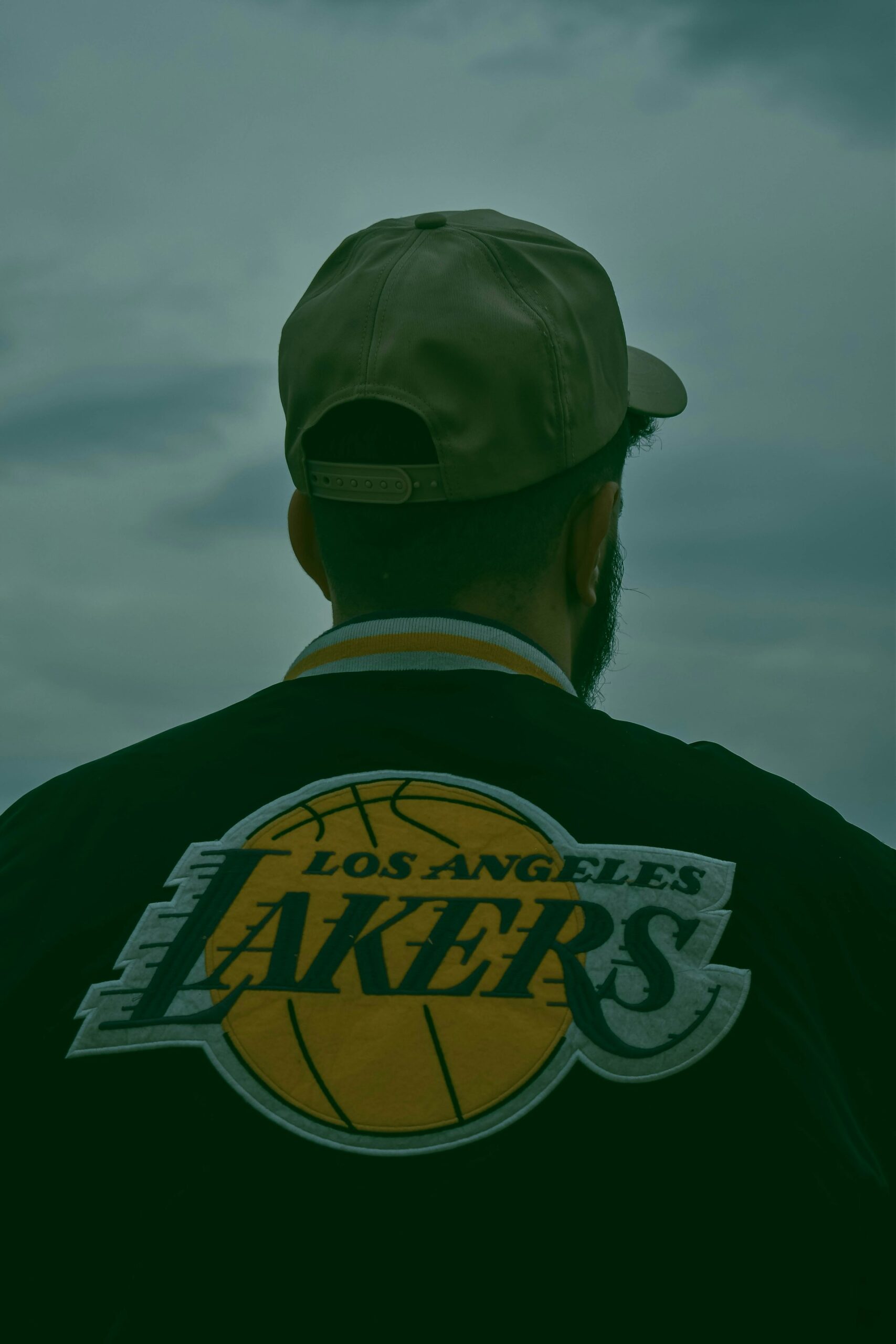 An image of a man dressed in a Lakers jacket from the back.