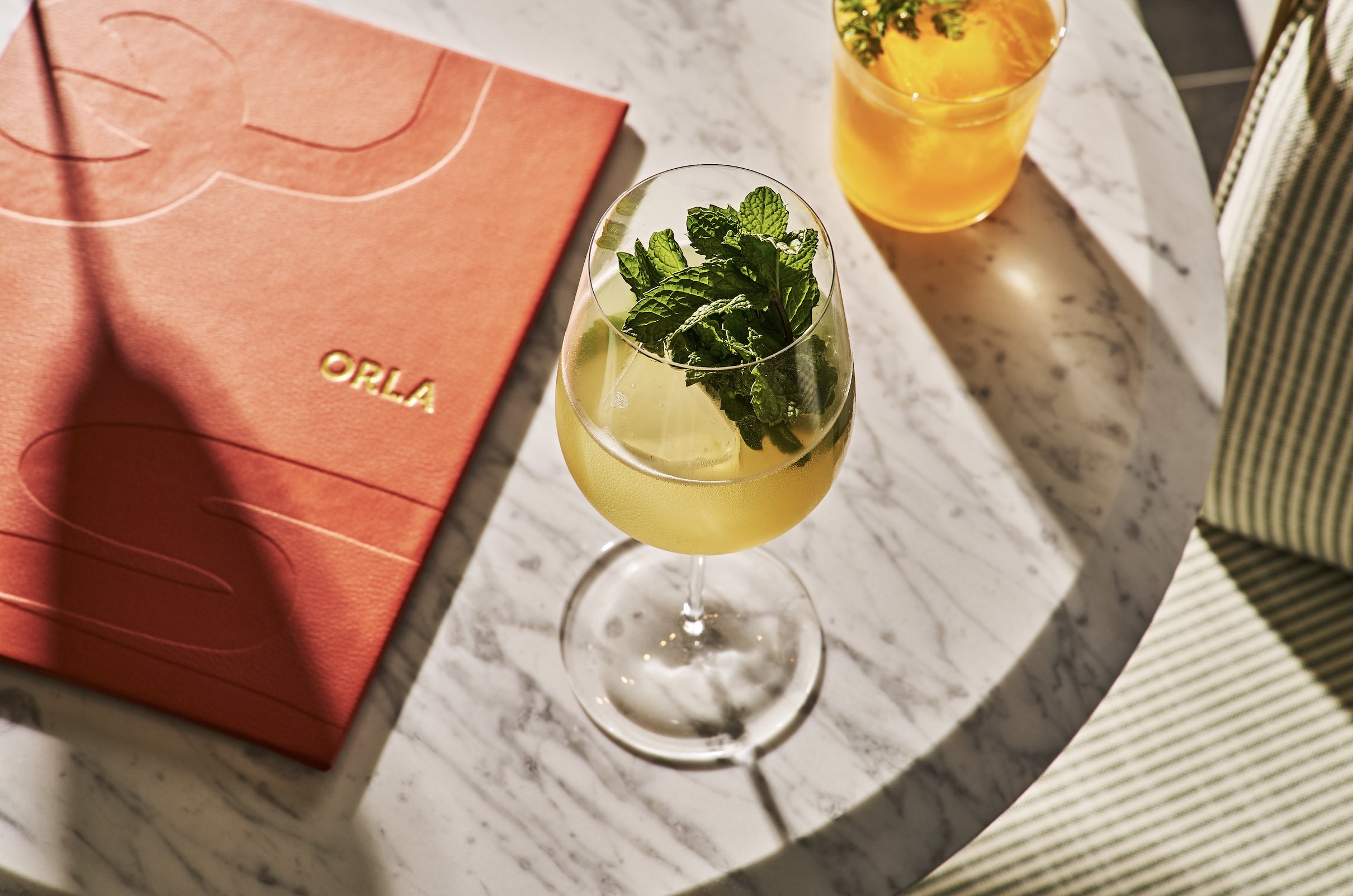 An image of the menu and a glass of wine at Orla.