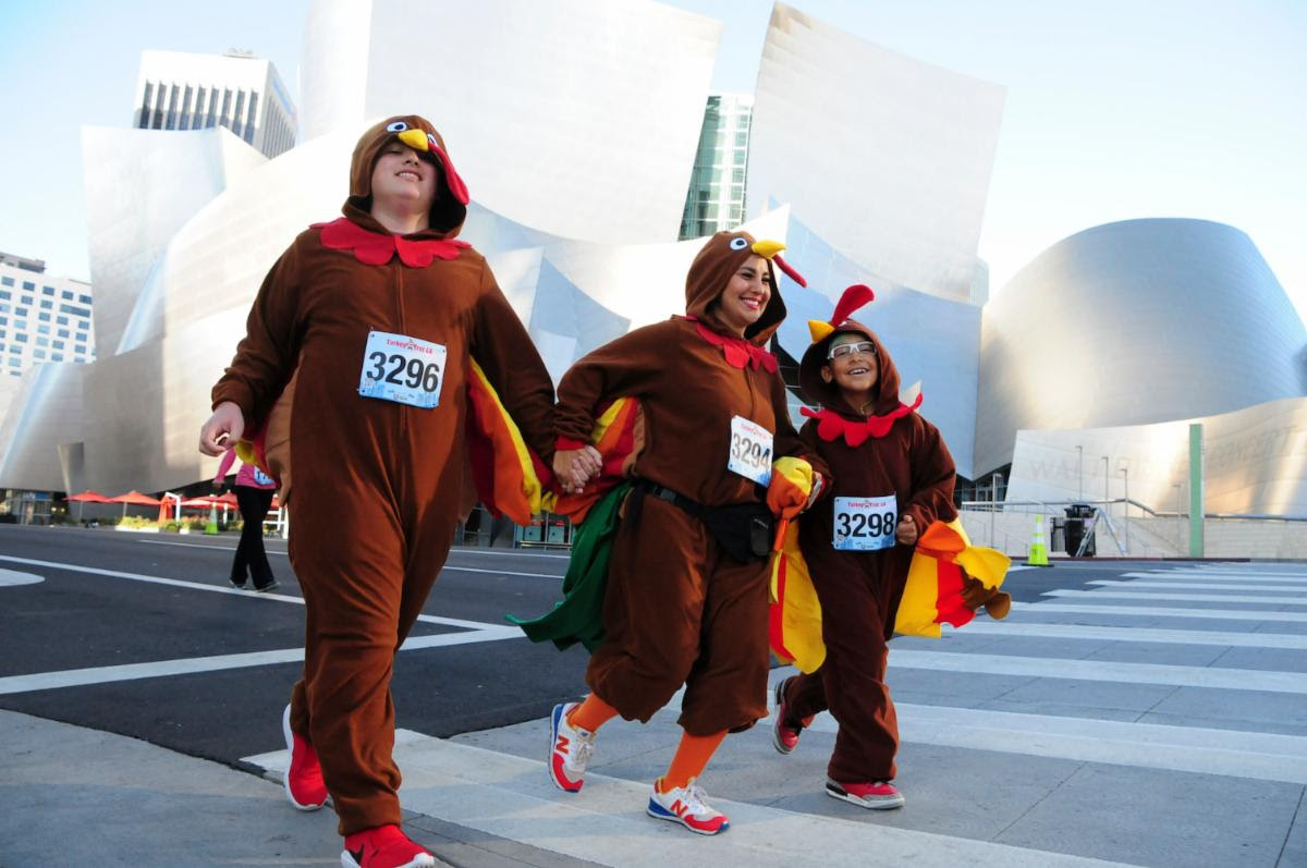 An image of three people dressed as turkey for the Turkey Trot.