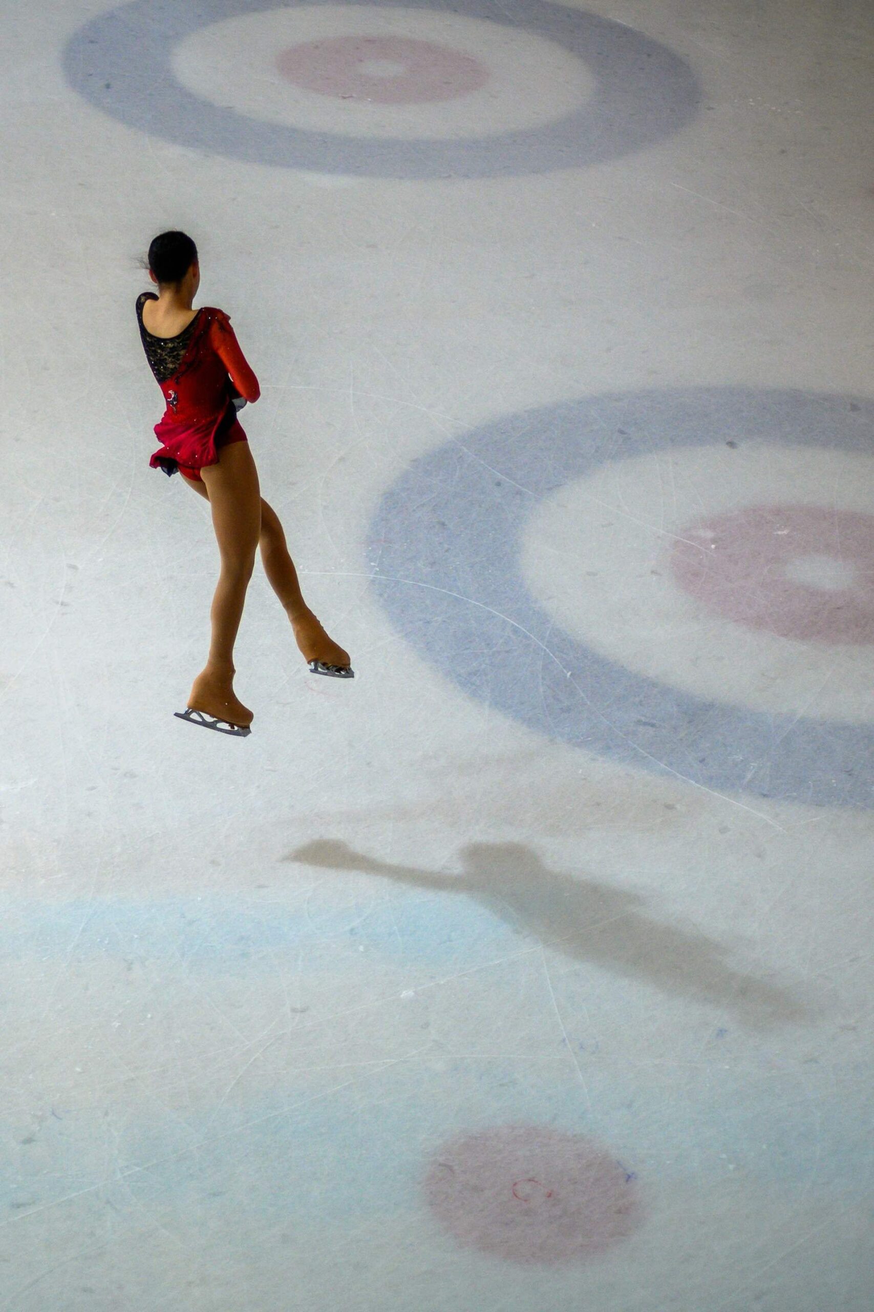 An image of a female ice skater doing a jump.