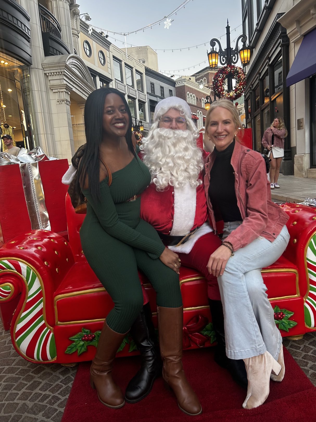 An image of lifestyle blogger Ariel Johns sitting with Santa and another friend.