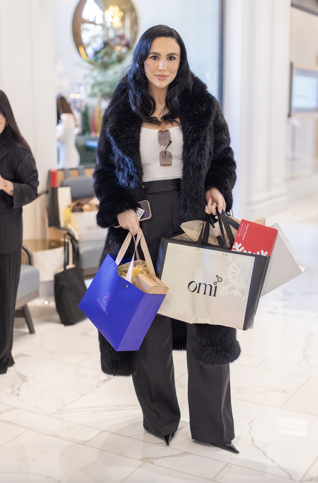 An image of a woman holding items from the The Modern Day Wife’s “Holiday Gift Guide”