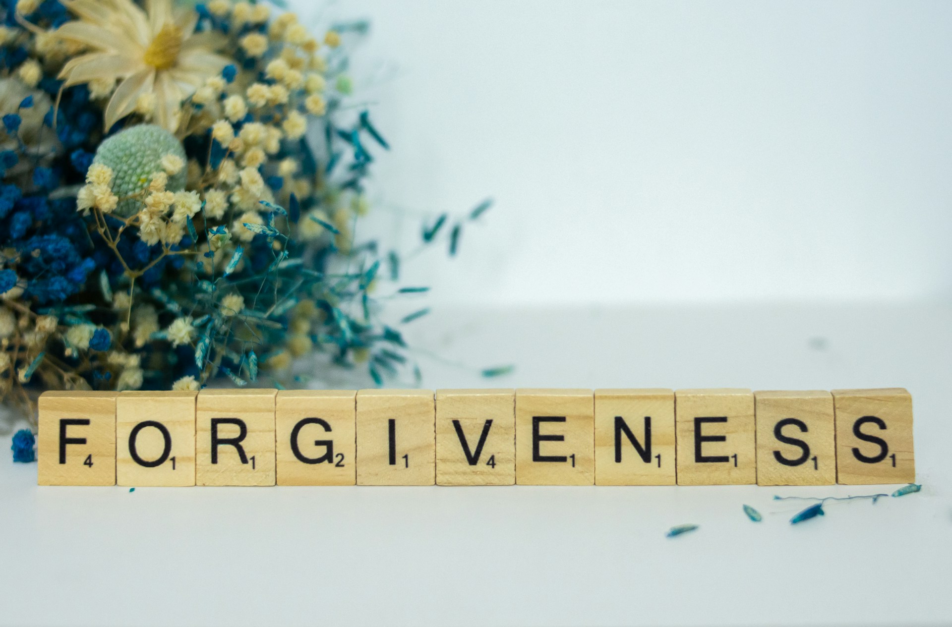 An image of tile letters that spells the word 'forgiveness'