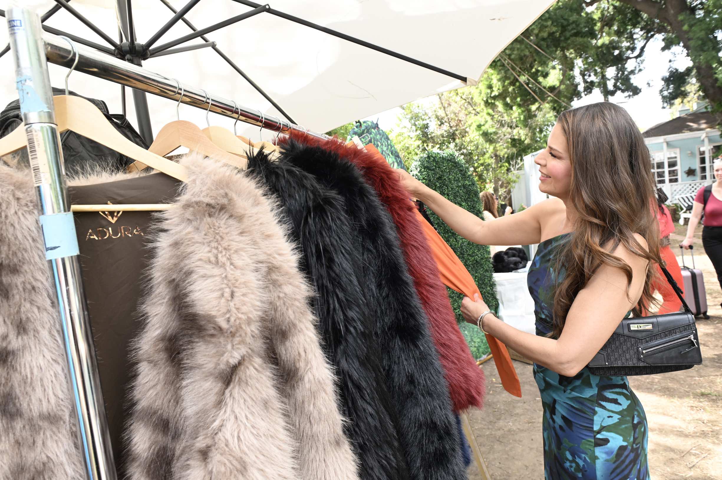 An image of a woman shopping the debut of FAYAH x ADURA Apparel men’s and women’s luxury golfwear and faux fur jackets
