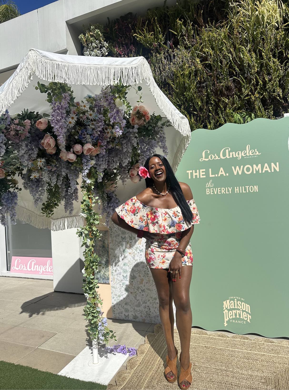 An image of lifestyle blogger Ariel Johns posing for a photo at the Beverly Hilton garden patio.
