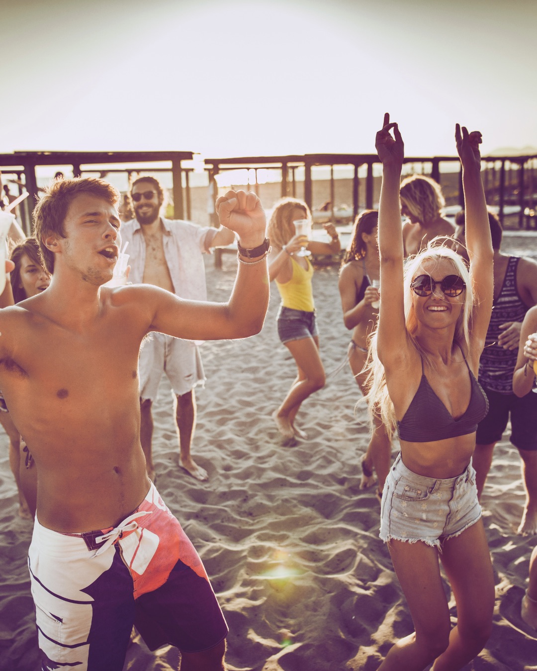 An image of people dancing at the beach.