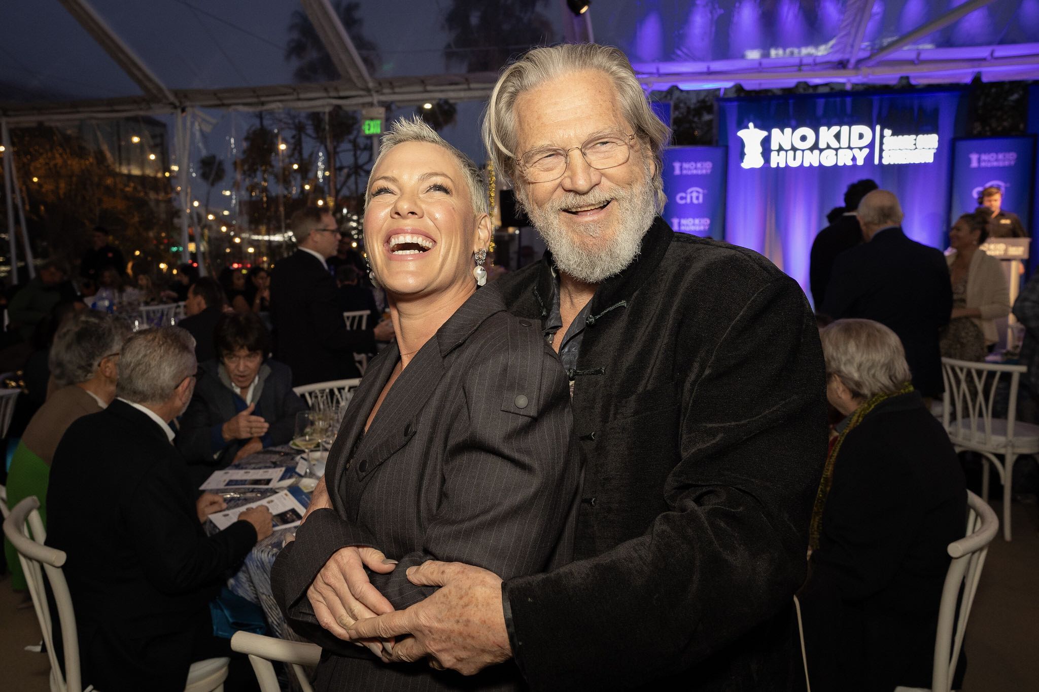 An image of P!NK and Jeff Bridges posing for the camera at a 2025 holiday-themed No Kid Hungry event. 