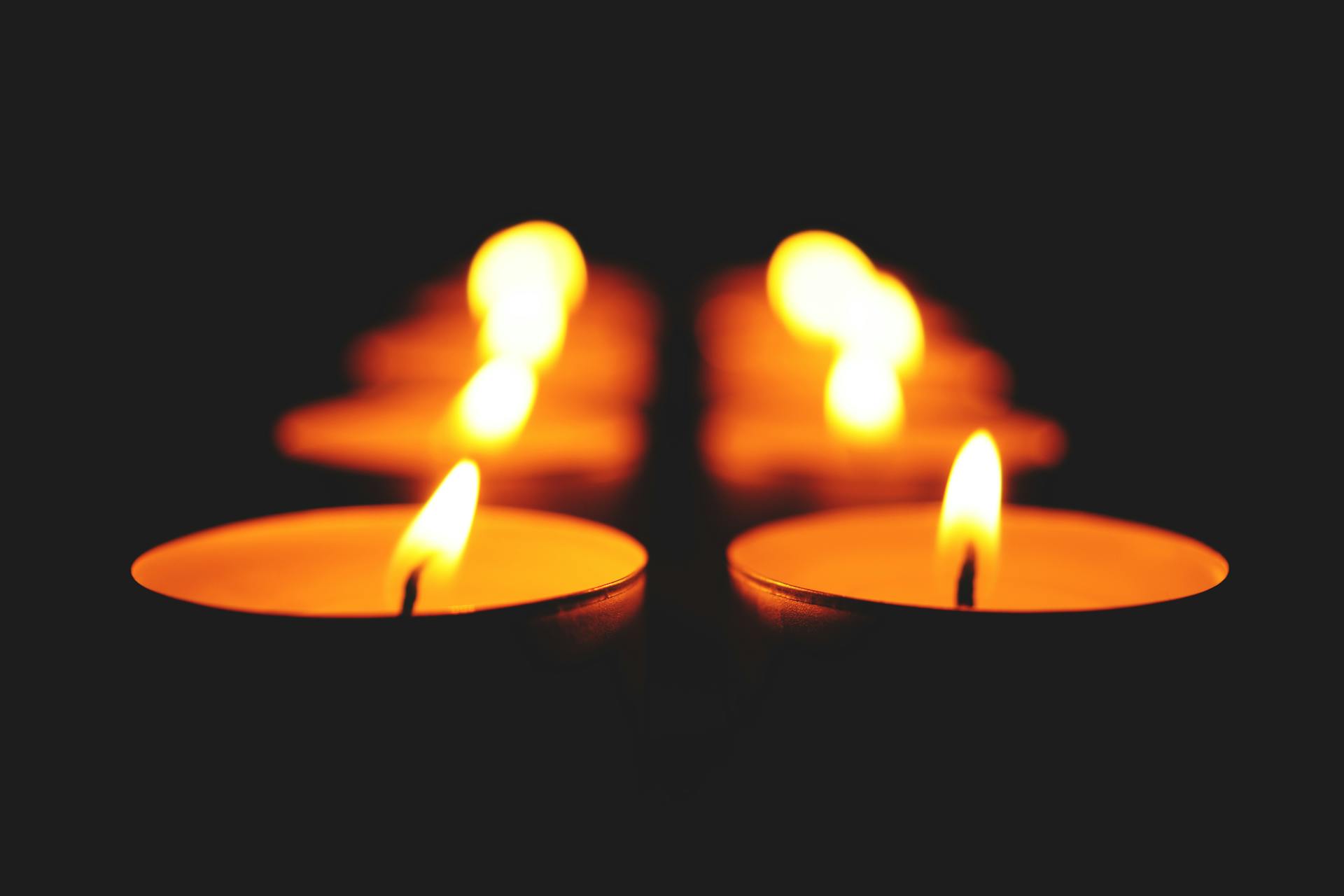 An image of lit candles in the dark.