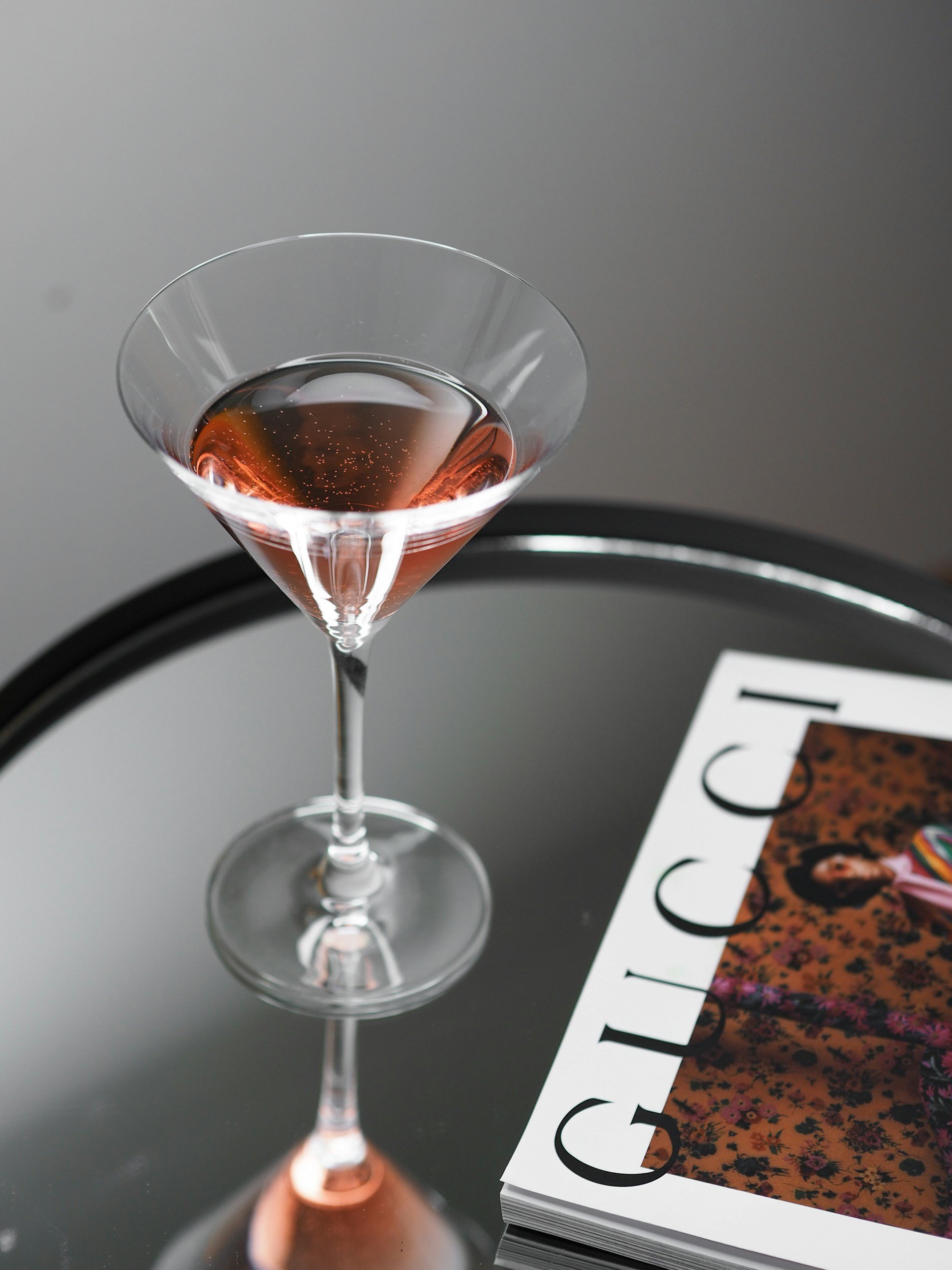 A image of a martini with a Gucci coffee table book.