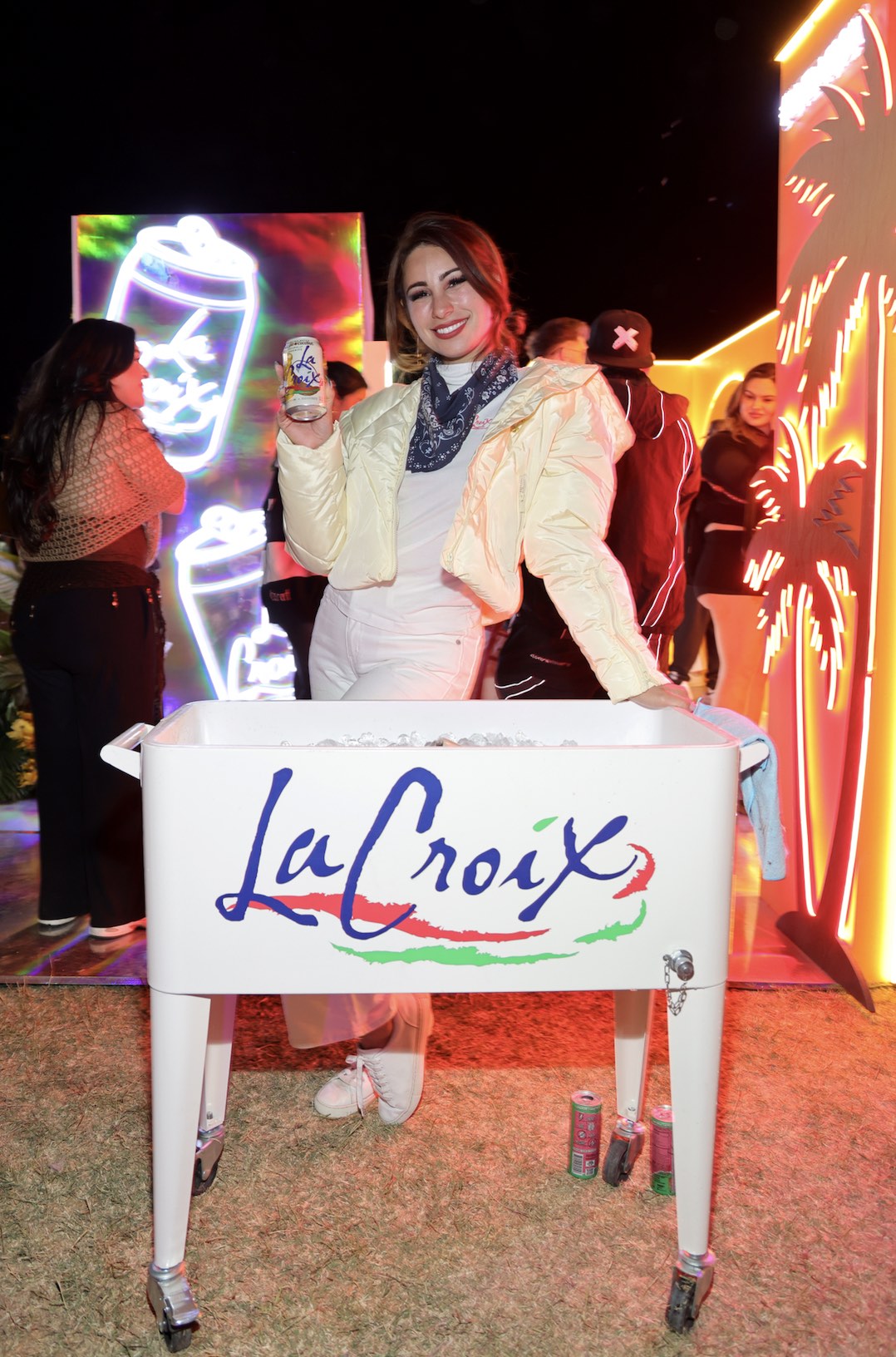 An image of a woman handing out La Croix sparkling water. 