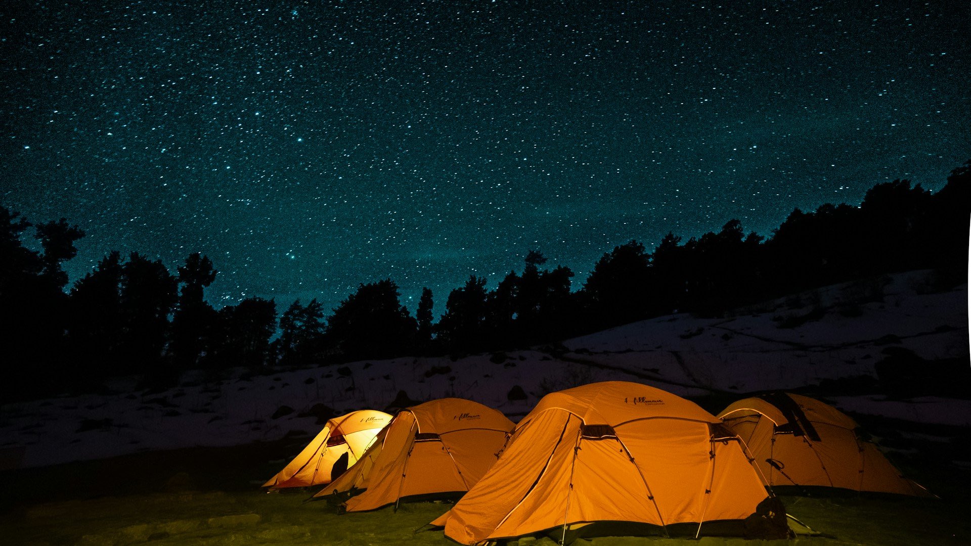 An image of stars above tents camping.