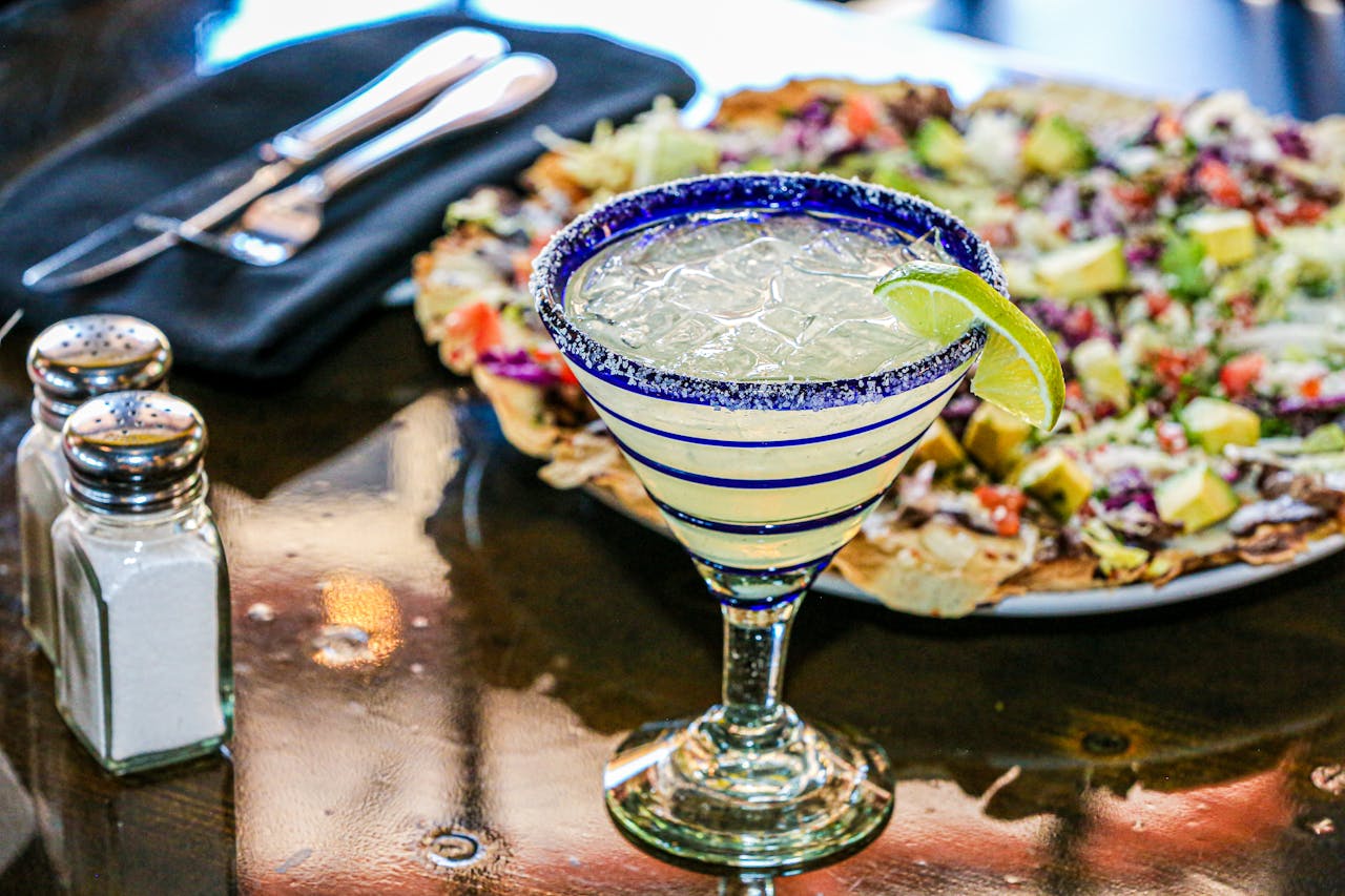 AN image of a margarita and nachos.