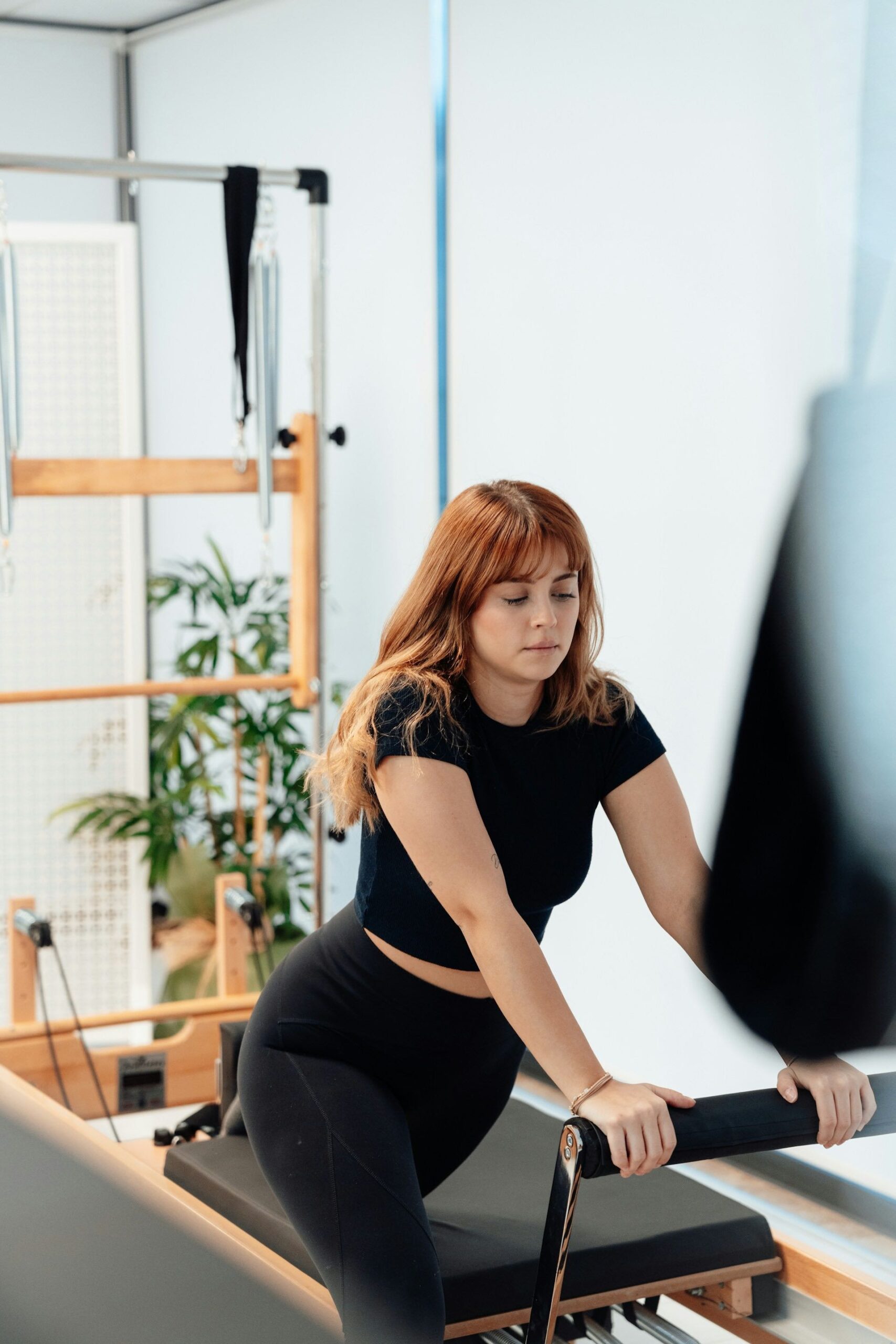 An image of a woman on a Pilates Reformer at Club Pilates