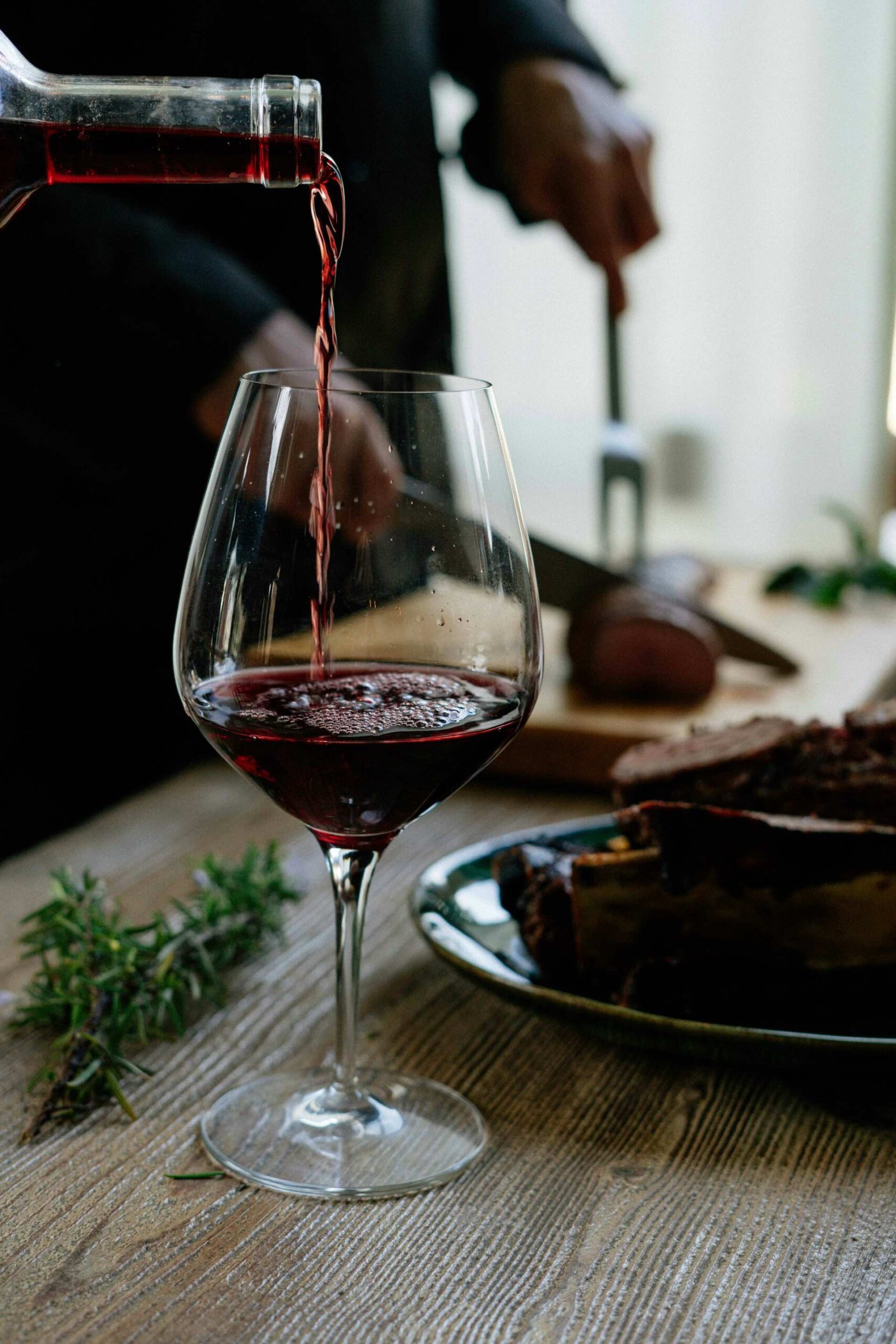 An image of a glass of red wine being poured.