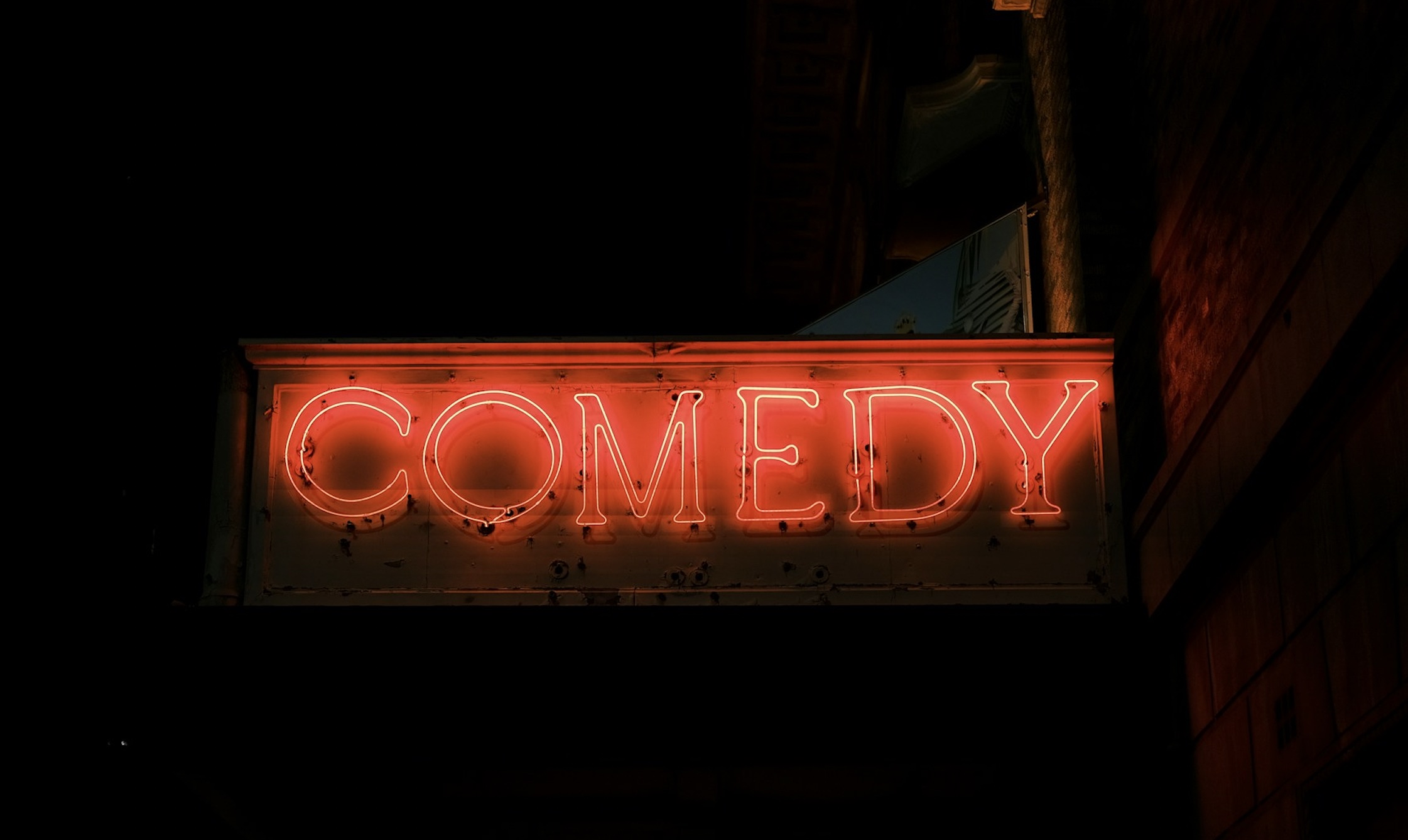 An image of a sign that has the word 'comedy.'