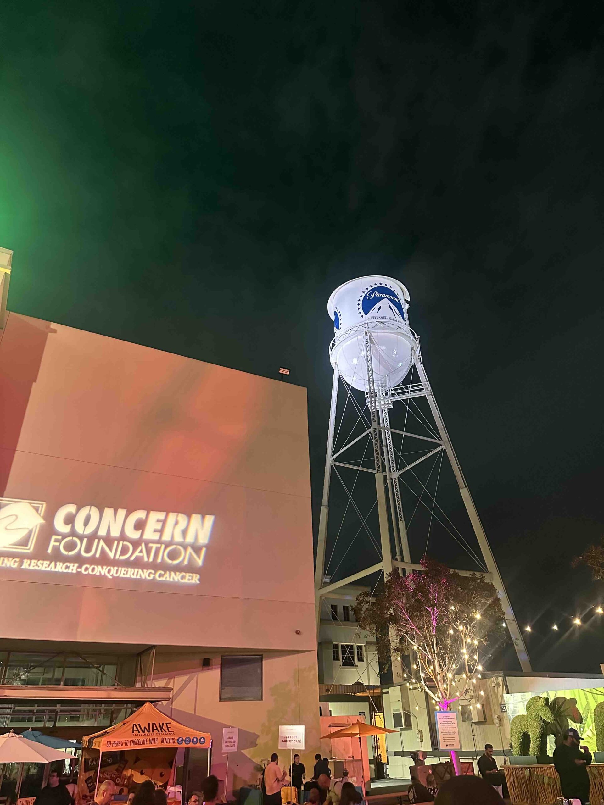 An image of the Concern Foundation 's marquee projected on the wall of the Paramount Studios backlot - with the Paramount water tower.