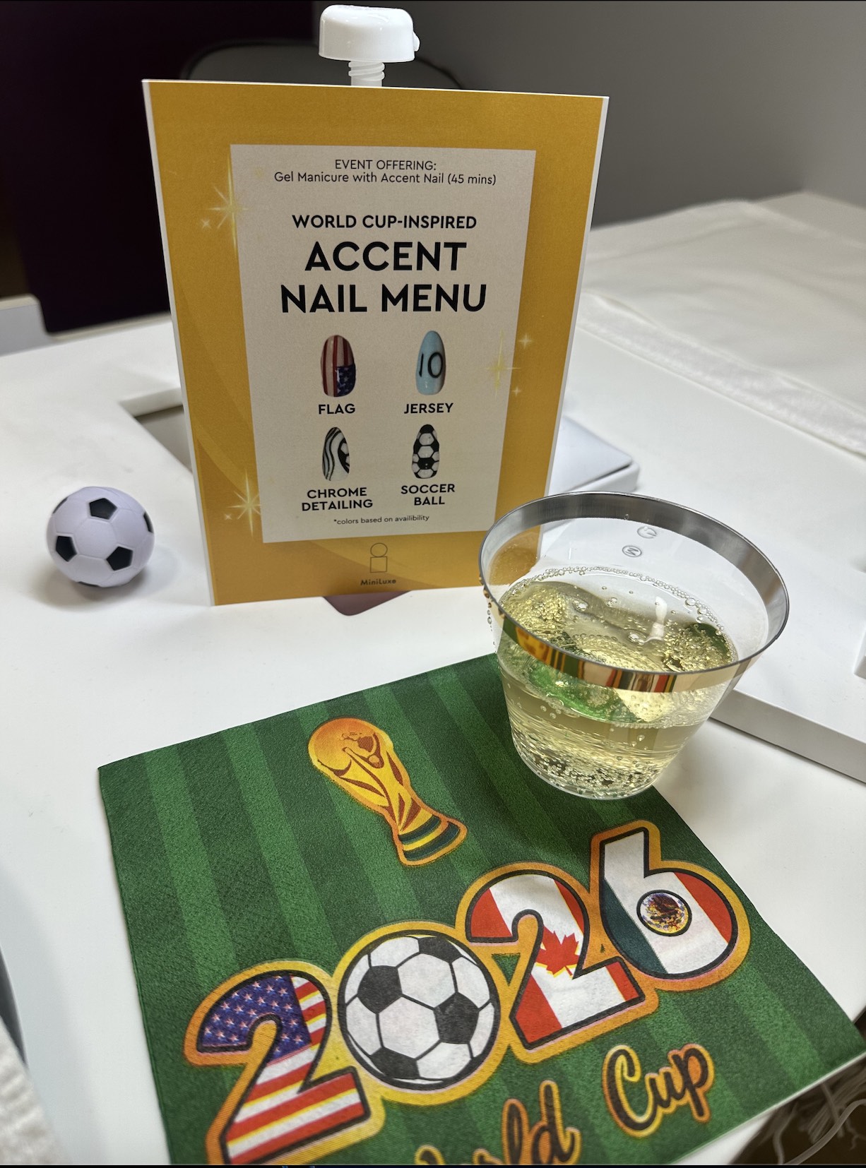 An image of a napkin and sign from the World Cup mani party at MiniLuxe.