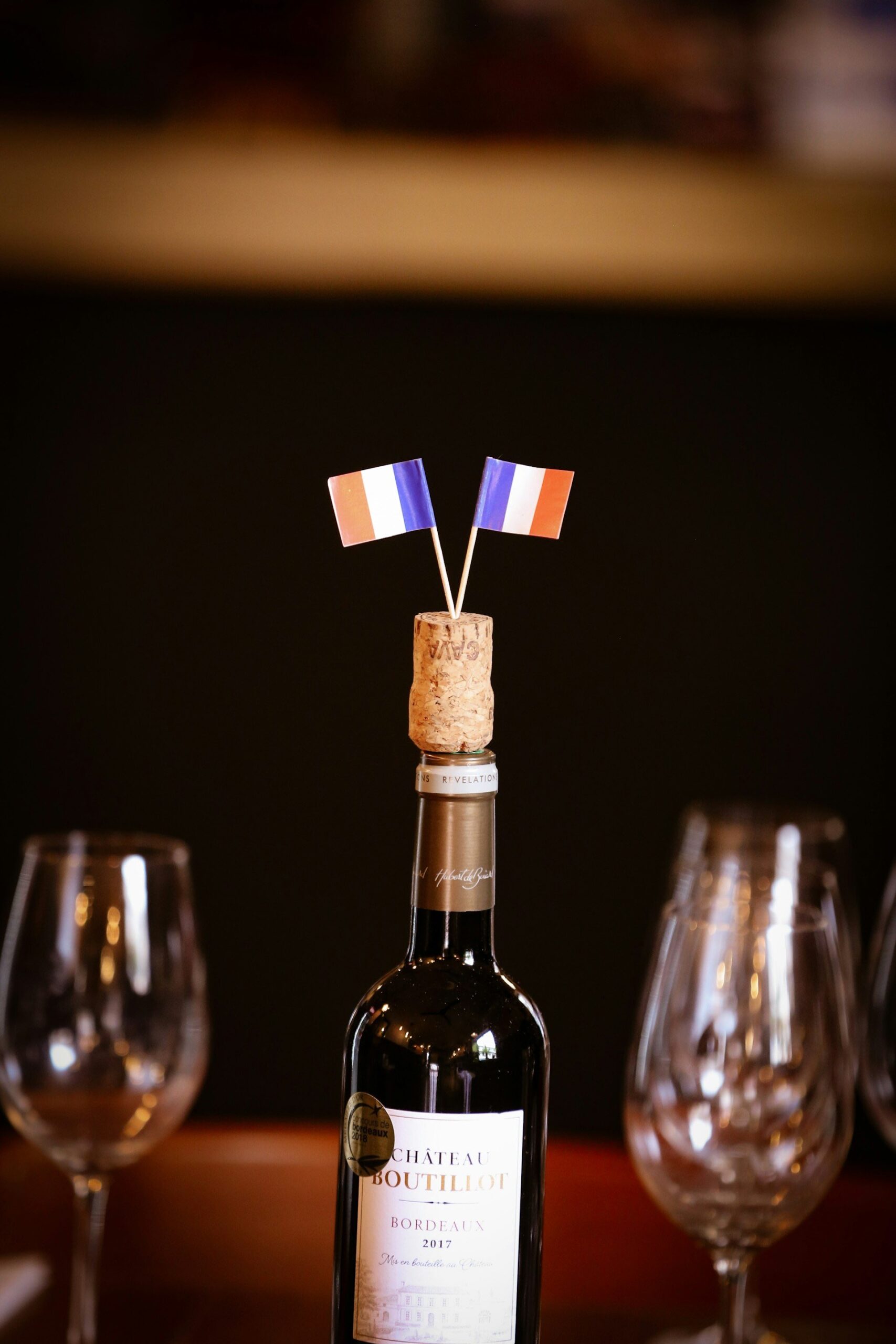 An image of a bottle of wine with mini French flags.