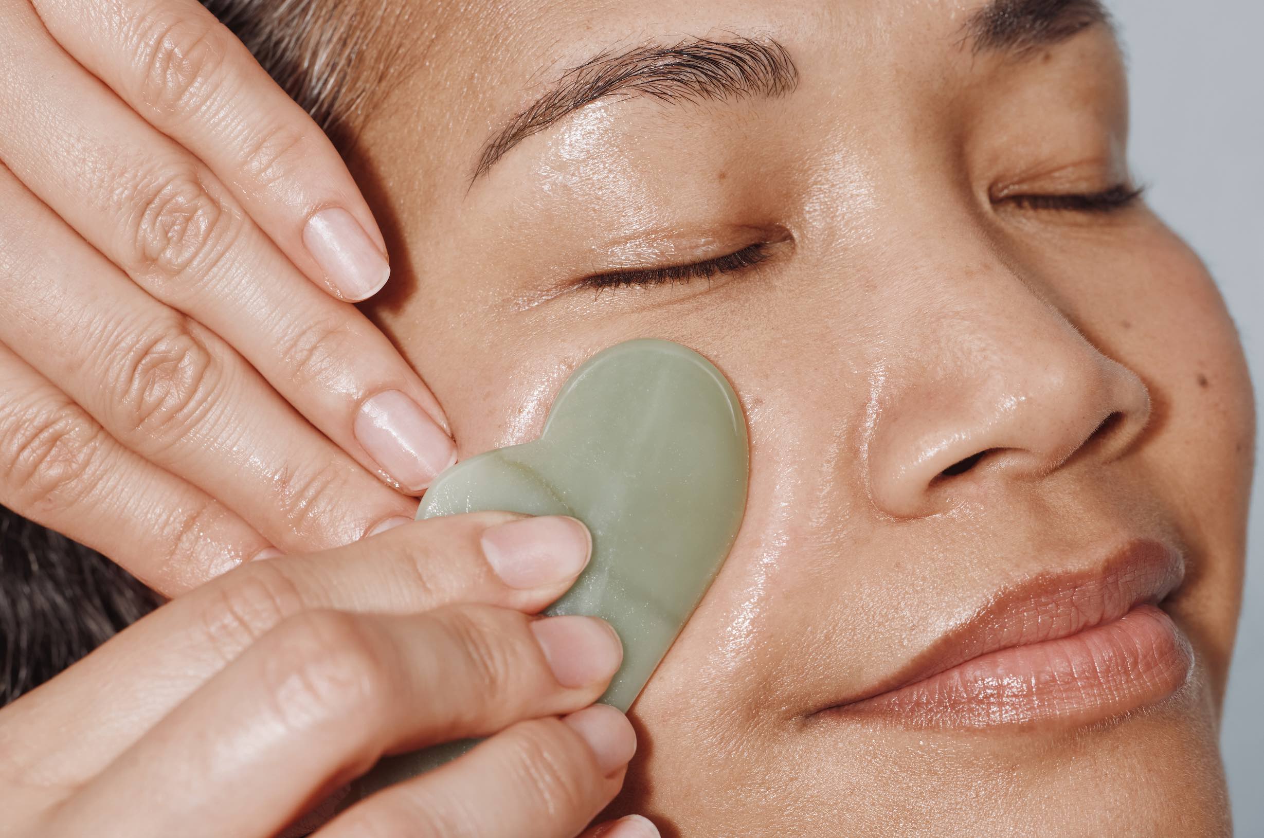 AN image of someone getting a complimentary Gua Sha add-on with any facial at Heyday.