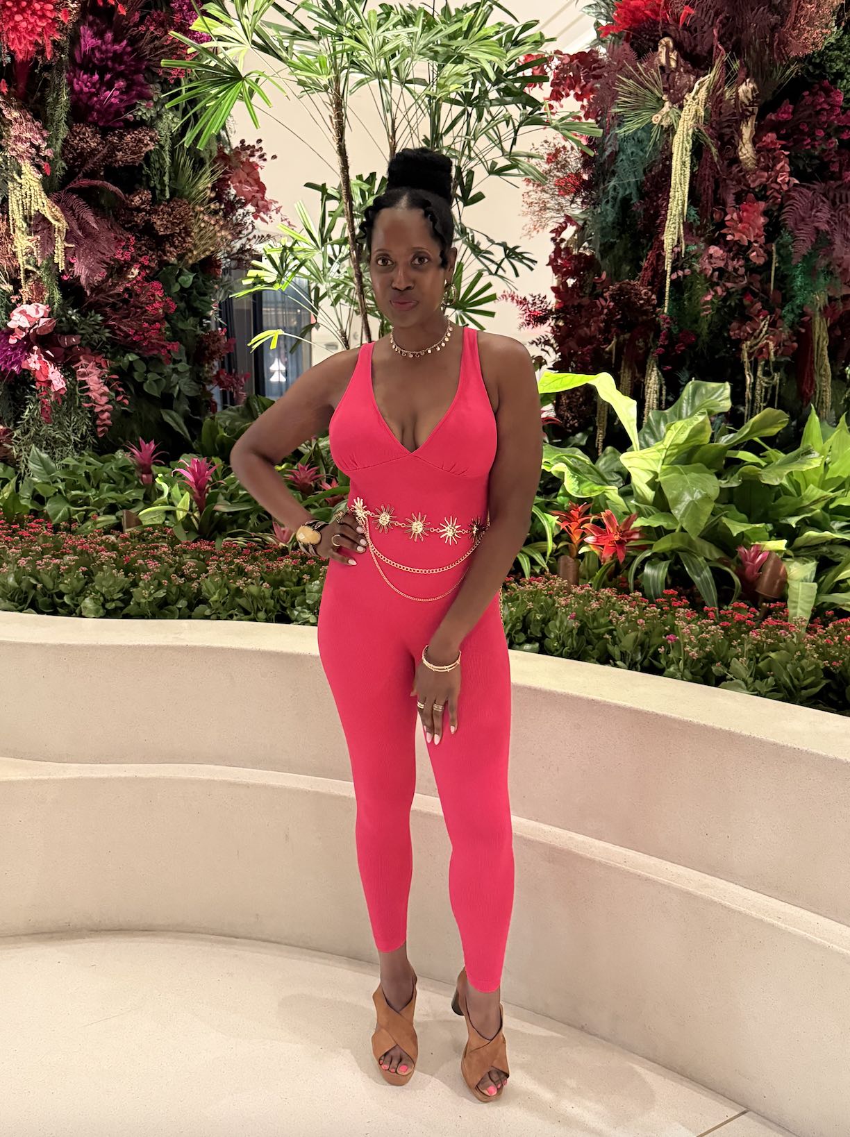 An image of lifestyle blogger Ariel Johns in a hot pink jumpsuit.