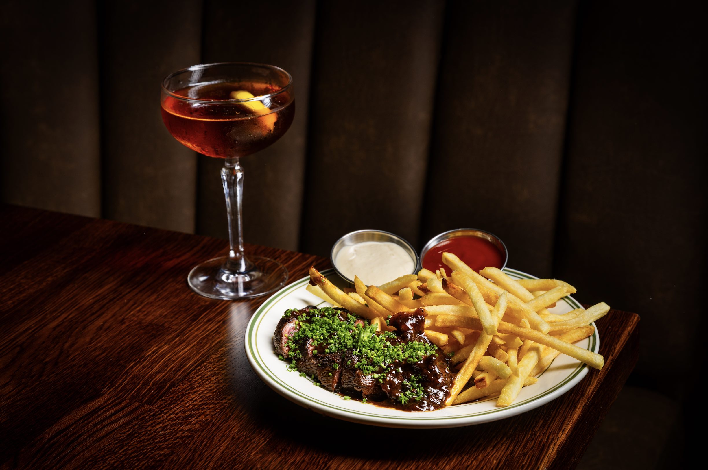An image of a cocktail and steak dinner from Bar Harry.