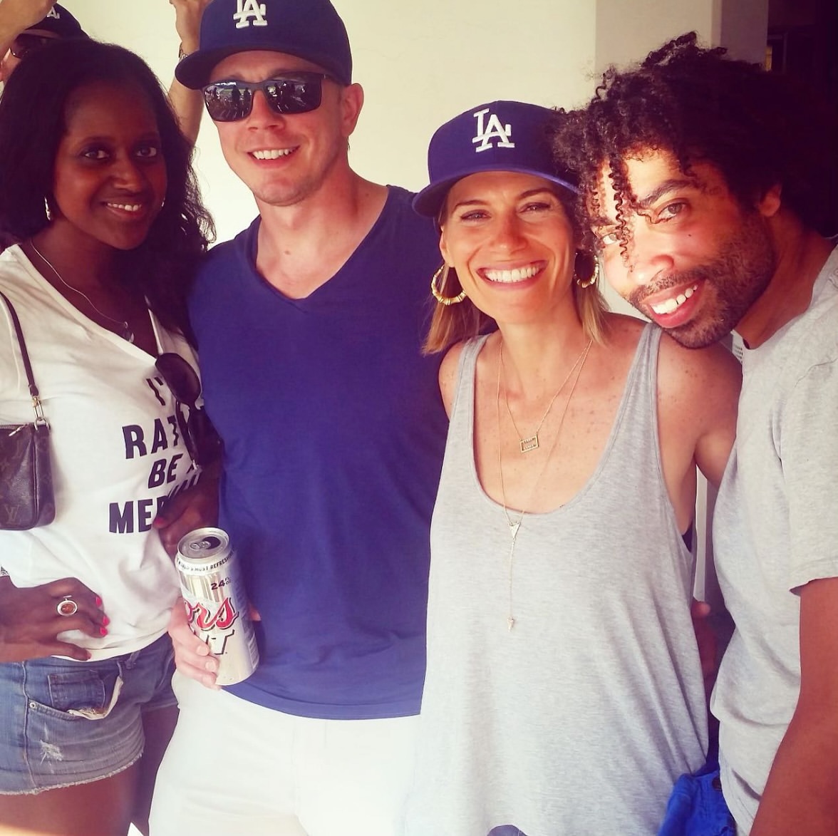 AN image of 4 people in Dodgers gear at Dodgers Stadium.